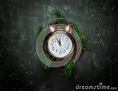 Vintage copper Alarm Clock Five Minutes to Midnight New Years Countdown Christmas Wreath Fir Tree Branches on Black Background Stock Photo