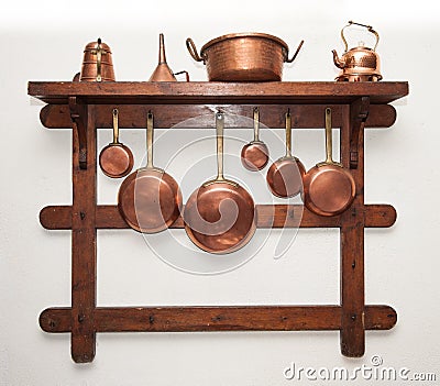 Vintage copper cookware hung on wooden shelf Stock Photo