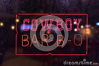 Vintage Cowboy BBQ Neon Sign in Rainy Window Stock Photo