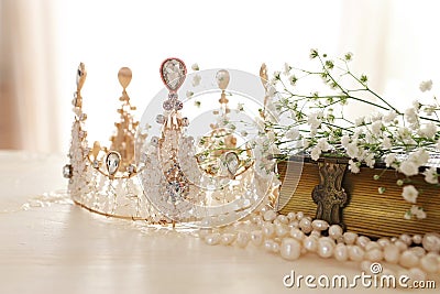 Vintage crown, antique book and pearls necklace. Wedding concept. Back light Stock Photo