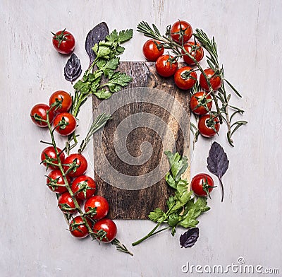 Vintage cutting board with herbs and vegetables on wooden rustic background top view close up place text,frame Stock Photo