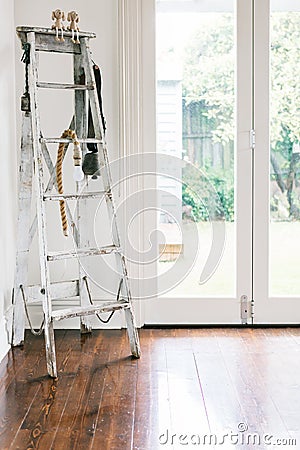 Vintage decor of an old ladder, farm bell and rope light in a co Stock Photo