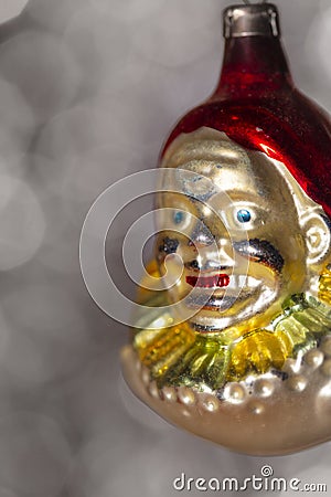 Vintage decorative christmas bauble in a shape of a crown jester against a silver bokeh blury star background Stock Photo