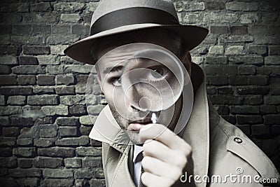 Vintage detective looking through a magnifier Stock Photo