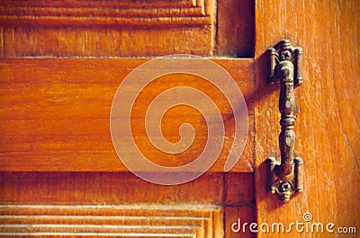 The vintage door handle on an old wooden door background and lighting and shadow in the morning. Stock Photo