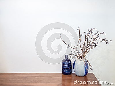 Vintage dried flower in ceramic vase decorate on wooden table on white wall background Stock Photo