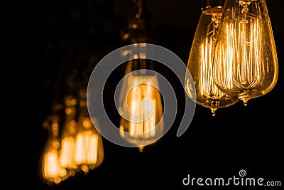 Vintage Edison Light Bulbs hanging against a black background Stock Photo