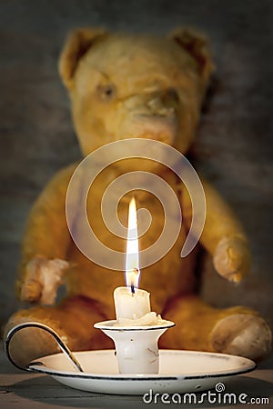Vintage Enamel Candle Holder with Old Teddy Bear Behind Stock Photo