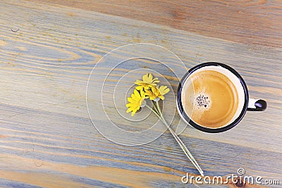 Vintage enamel coffee cup and daisy flowers on wooden table. Stock Photo