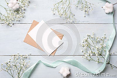 Vintage envelope with flowers on light blue wooden background. Banner mockup for womans or mother day, wedding invintation, easter Stock Photo