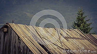 Vintage faded image of an old wooden barn roof falling apart dew to lack of maintenance, a mountain farm Stock Photo