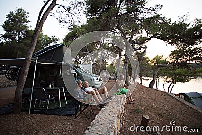 Family rest in forest next to camping van Editorial Stock Photo