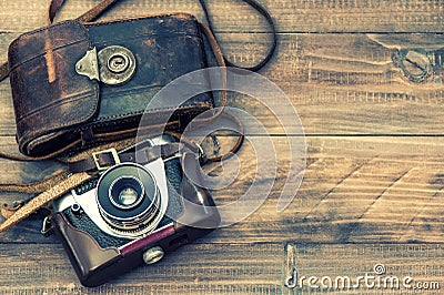 Vintage film photo camera with leather bag on wooden background Stock Photo