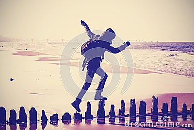 Vintage filtered silhouette of a woman running on wooden posts. Stock Photo