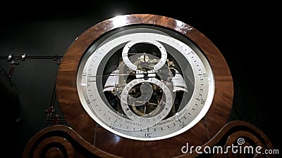 Vintage floor clock in Museum. Action. Old large clock with beautiful dials are behind window in Museum. Museum of Editorial Stock Photo