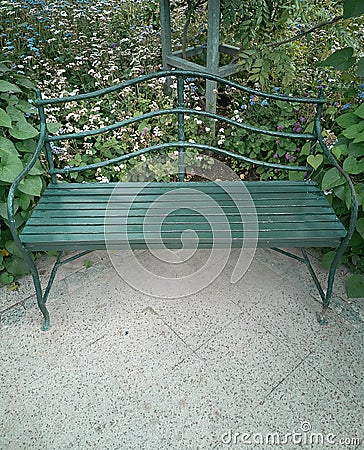 Vintage garden bench among flowers and greenery Stock Photo