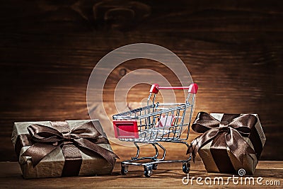 Vintage giftboxes and shopping cart on wood Stock Photo