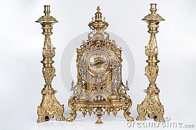 Vintage gold watch with candelabra on white background, bronze clock and candelabra, gold candlesticks and clock, antique clock an Stock Photo