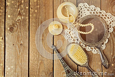 Vintage hand mirror and hairbrush with Eiffel Tower on wooden background. Stock Photo