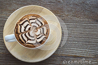 Vintage hot coffee cup with nice Latte art decoration on old woo Stock Photo