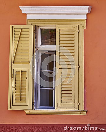 Vintage house pale yellow shutters window Stock Photo
