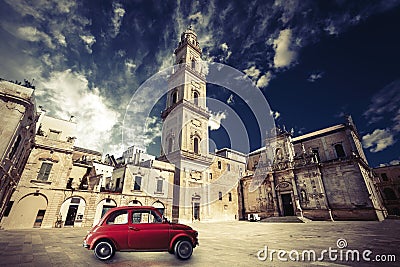 Vintage Italian scene, an old church with a bell tower and old small red car Stock Photo