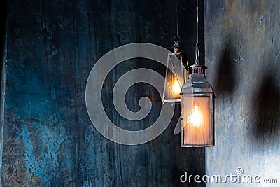 vintage Lantern hangs in the night.hanging iron black lanterns with big glasses burning in the dark of the night Stock Photo