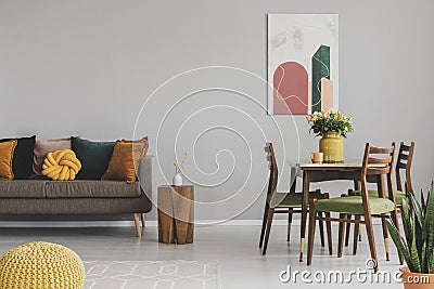 Vintage living and dining room interior with retro table with chairs and comfortable sofa with pillows Stock Photo