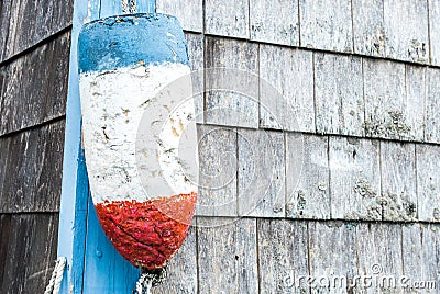 Vintage lobster buoy hanging on the corner of a fishing shack Stock Photo