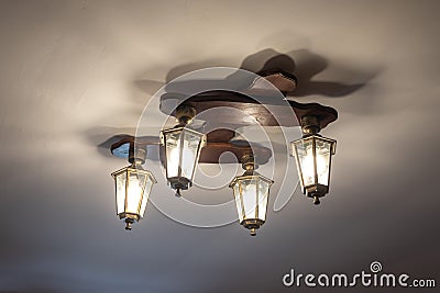 Vintage lustre with decorative lanterns hangs on ceiling Stock Photo