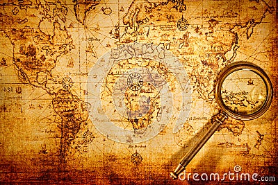 Vintage magnifying glass lies on an ancient world map Stock Photo