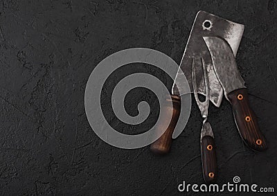 Vintage meat knife and fork and hatchet on black table background. Butcher utensils. Space for text Stock Photo