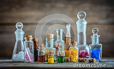 Vintage medications in small bottles on wood desk. Old medical, chemistry and pharmacy history concept background. Retro style Stock Photo