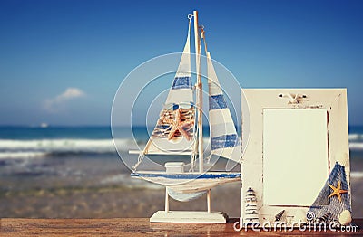 Vintage nautical frame with starfish on wooden table and sea beach background. retro filtered image Stock Photo