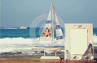 Vintage nautical frame with starfish on wooden table and sea beach background. retro filtered image Stock Photo