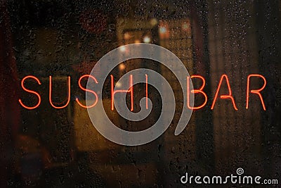 Vintage Neon Sushi Bar Sign in Wet Rainy Window Stock Photo