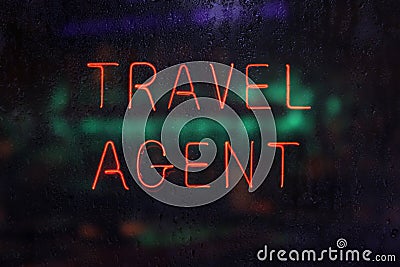 Neon Travel Agent Sign in Rainy Window Stock Photo