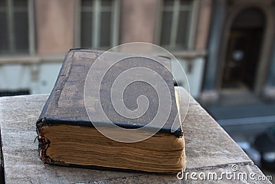 Vintage old book on stone, grunge textured cover. Retro styled image with blurred background. Stock Photo