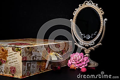 Vintage Oval Desk Mirror with white frame, Potpourri pieces and a keepsake box on black background Stock Photo