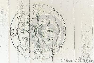 Round ornate metal medallion hanging on wooden wall Stock Photo