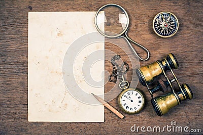 Vintage paper for map, old binoculars, compass, pocket watch,pencil, rope, magnifying glass on wooden background Stock Photo