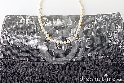 Vintage pearl jewelry on little black dress. Gatsby or Chicago fashion look. Luxury white necklace. Getting ready for party. Stock Photo