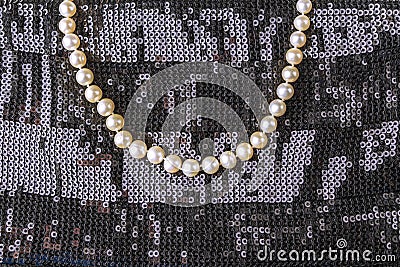 Vintage pearl jewelry on little black dress. Gatsby or Chicago fashion look. Luxury white necklace. Getting ready for party. Stock Photo