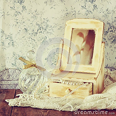 Vintage pearls , antique wooden jewelry box with mirror and perfume bottle Stock Photo