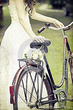 Vintage photo of bride and wedding bouquet on a bicycle Stock Photo