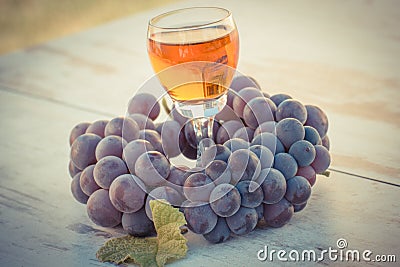 Vintage photo, Grapes with leaf and glass of wine on wooden table in garden Stock Photo