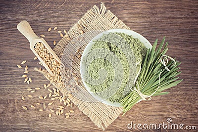 Vintage photo, Heap of young powder barley, barley grass and grain on jute canvas, wooden background Stock Photo