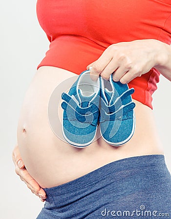 Vintage photo, Pregnant woman with baby shoes, expecting for baby Stock Photo