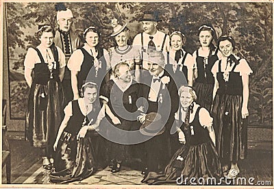 The vintage photo shows a group of people celebrating social event. Carnival masquerade ball dancing party Editorial Stock Photo