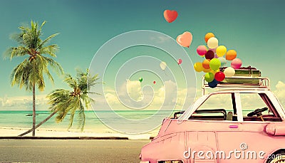 Vintage pink classic car with heart colorful balloon on beach blue sky Stock Photo